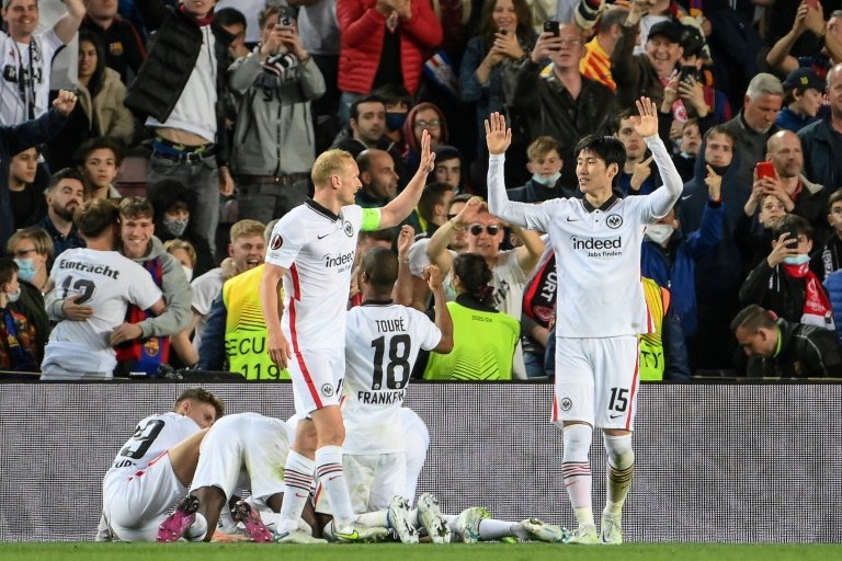 Favourites Barcelona were dumped out of the Europa League by Eintracht Frankfurt in the quarter-finals on Thursday while West Ham United joined RB Leipzig in qualifying for the last four. Serbian international Filip Kostic scored twice either side of a Rafael Santos Borre strike at the Camp Nou for Frankfurt, who survived a late fightback from the hosts to win 3-2 on the night and 4-3 on aggregate. Sergio Busquets scored a late consolation before Memphis Depay's even later penalty for Barcelona but Eintracht held on, to the delight of the estimated 30,000 German supporters who travelled to Catalonia for the game. They go through to their second Europa League semi-final in four seasons, having lost on penalties to Chelsea at the same stage in 2019. However it was a desperately disappointing defeat for Barcelona, whose recent revival under Xavi Hernandez has been remarkable but who have managed to win just once at home in Europe all season. Sitting 12 points behind leaders Real Madrid in La Liga, the campaign is now almost certain to end without silverware for the Catalans, although they are at least on course to qualify for next season's Champions League. After conceding three penalties in their weekend win over Levante, Barca fell behind to another spot-kick inside four minutes against Eintracht, as Kostic converted from 12 yards after a foul by Eric Garcia to the delight of the enormous away support. The visitors scored again in the 36th minute as Colombian forward Borre fired high into the net from range, and Kostic's low finish into the far corner made it 3-0 midway through the second half. Busquets had a late goal disallowed for offside before he found the net with a fantastic strike from 20 metres in the first minute of injury time. The game carried on into an 11th added minute when Depay netted a penalty after Evan Ndicka had been sent off, receiving a second yellow card for a foul on Luuk de Jong. - West ham outclass Lyon - Yet Eintracht maintained their record of not having lost to Spanish opposition since the 1960 European Cup final against Real Madrid, and they will face West Ham in the semi-finals. RTL West Ham captain Declan Rice gets a ride on the back of Vladimir Coufal as they celebrate beating Lyon / © AFP The Premier League side are through to their first European semi-final since they lost the 1976 Cup Winners' Cup final to Anderlecht after outclassing Lyon in France. Having drawn 1-1 at home in last week's first leg despite playing half the game with 10 men, the Hammers took the lead in the 38th minute of the return when Craig Dawson headed in a Pablo Fornals corner at the near post. Captain Declan Rice slotted in their second goal just before the break, his sidefoot effort from the edge of the area beating Lyon goalkeeper Julian Pollersbeck with the aid of a slight deflection. The outcome was put beyond doubt when West Ham scored again three minutes after the restart as Fornals sent Jarrod Bowen away to make it 3-0. Earlier the in-form Christopher Nkunku scored both goals as Leipzig beat Atalanta 2-0 in Italy to win their last-eight tie 3-1 on aggregate. The Germans had come from behind to draw 1-1 at home in the first leg last week and they went in front in the 18th minute in Bergamo as Konrad Laimer cut the ball back from the right for Nkunku to score. Leipzig wrapped up the victory with three minutes left as Nkunku converted a penalty he himself had won. That goal was the 30th of the season in all competitions for Nkunku, who made his full international debut for France last month. Leipzig, who reached the Champions League semi-finals two years ago, advance to a last-four tie against either Braga or Rangers. Their second leg went to extra time with Rangers beating Braga 2-1 in 90 minutes in Glasgow after losing 1-0 in the first leg.