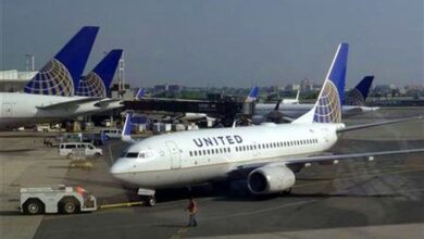 Photo of US man opens emergency exit door of taxiing airplane, walks on wing